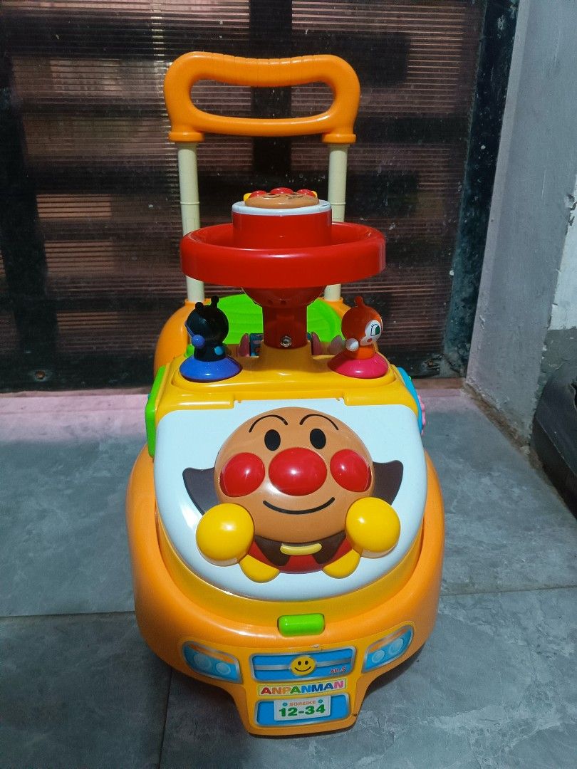 Anpanman Ride-On Push Walker Toy with Handle (Category: Kids Toys) located in Manila. Submitted by mateochest99469 (Listing ID 1469482189, Image 1). Description: - Bright orange Anpanman ride-on walker perfect for toddlers learning to walk - Includes interactive steering wheel and cute Baikinman character figures - Convenient push handle at the back for parents - Features colorful stickers and a green seat that lifts up for storage - Clean plasti