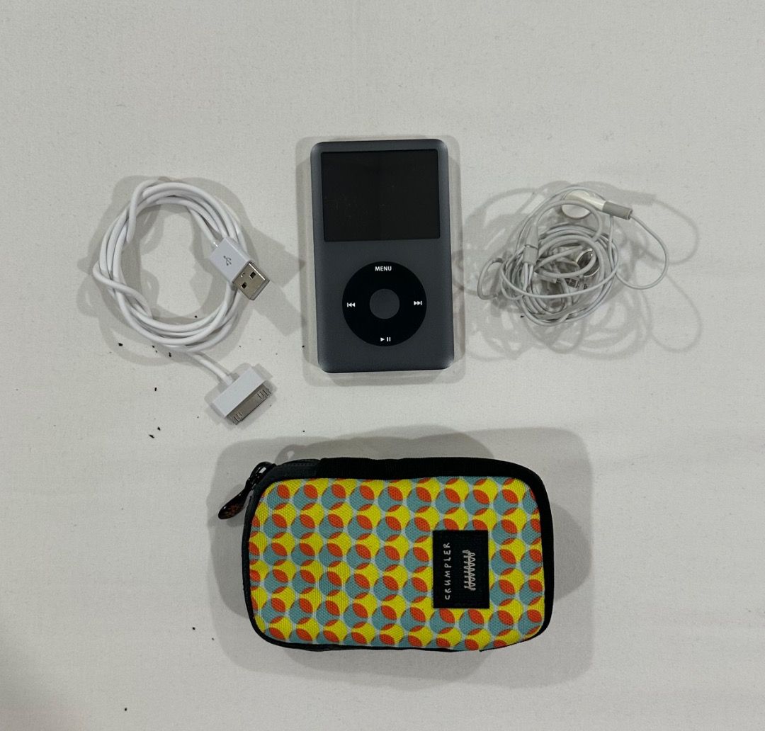 Apple iPod Classic 160GB with Case (Category: Portable Music Players) located in San Juan City. Submitted by looneybin559 (Listing ID 1469438313, Image 3). Description: - Model: Apple iPod Classic (160GB, Dark Grey Silver) - Condition: Fully working, screen turns on clearly, charges normally - Flaws: Minor scratches on the chrome back panel from normal use - Inclusions: 30-pin USB sync charging cable, wired Apple earphones, and a colourful patter