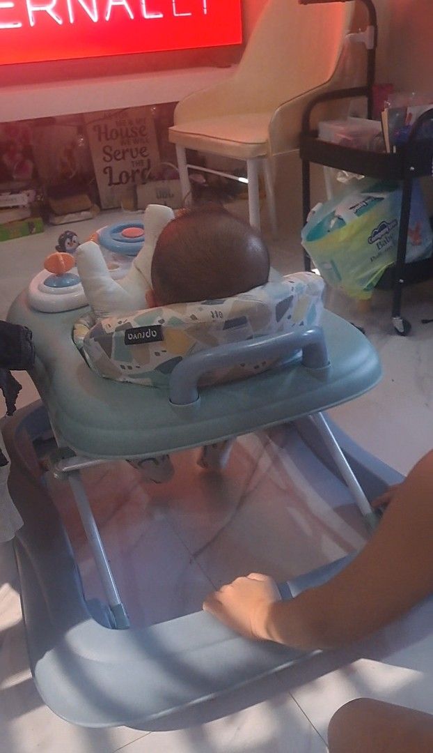 Apruva Baby Walker with Toy Tray (Category: Infant Playtime) located in Gapan. Submitted by smallfinds.ph (Listing ID 1469403623, Image 2). Description: - Brand: Apruva Baby Walker - Color: Green and Grey - Comfort: Soft padded seat with back support - Fun Features: Interactive toy tray with steering wheel and penguin toy - Safety & Design: Stable base design with a wide footrest area underneath - Ideal for: Little ones learning to walk.