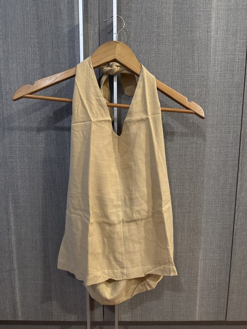 Araw Linen Halter Top (Category: Sleeveless) located in Makati City. Submitted by kkk.shops (Listing ID 1469508877, Image 1). Description: - Design: Halter neck with adjustable tie-back closure and stylish open back - Fabric: Linen - Versatility: Easily pairs with any denim, skirts, or shorts - Condition: Clean and well-maintained.