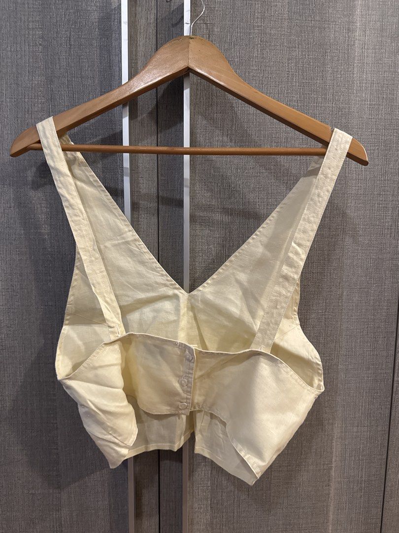 Araw Linen Top (Category: Sleeveless) located in Makati City. Submitted by kkk.shops (Listing ID 1469509106, Image 2). Description: - Color: Cream - Material: Lightweight linen, perfect for warm weather - Design: Deep V-neckline on front and back with back button closure - Styling: Easily pairs with high-waisted denim or skirts - Condition: Clean inside and out, ready to wear.