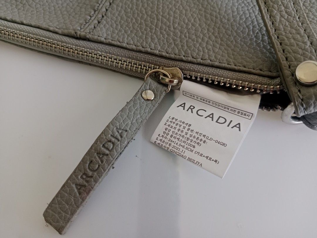 ARCADIA Grey Bucket Bag LD-04GR (Category: Shoulder Bags) located in Manila. Submitted by eze_em8 (Listing ID 1469471401, Image 3). Description: - Brand: ARCADIA - Style: Grey Leather Bag (Model LD-04GR) - Condition: Brand new with product tag attached - Material: Genuine leather exterior with synthetic lining - Dimensions: 24 cm (L) x 14.5 cm (H) x 6.5 cm (W) - Closure: Top zipper with branded leather pull tab - Design details: Stylish vertical 