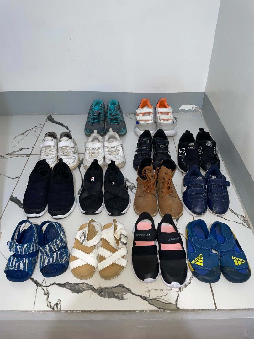 Assorted Kids Shoes and Sandals Bundle (Category: Babies & Kids Fashion) located in Cavite. Submitted by tobias_7795 (Listing ID 1469516188, Image 2). Description: - Massive bundle of kids footwear (selling as a set) - Includes top brands: Adidas, Fila, New Balance, and Nike - Variety of styles: sneakers, slip-ons, sandals, boots, and walking shoes - Assorted colors: black, white, blue, brown, and grey - Various sizes included across pairs.