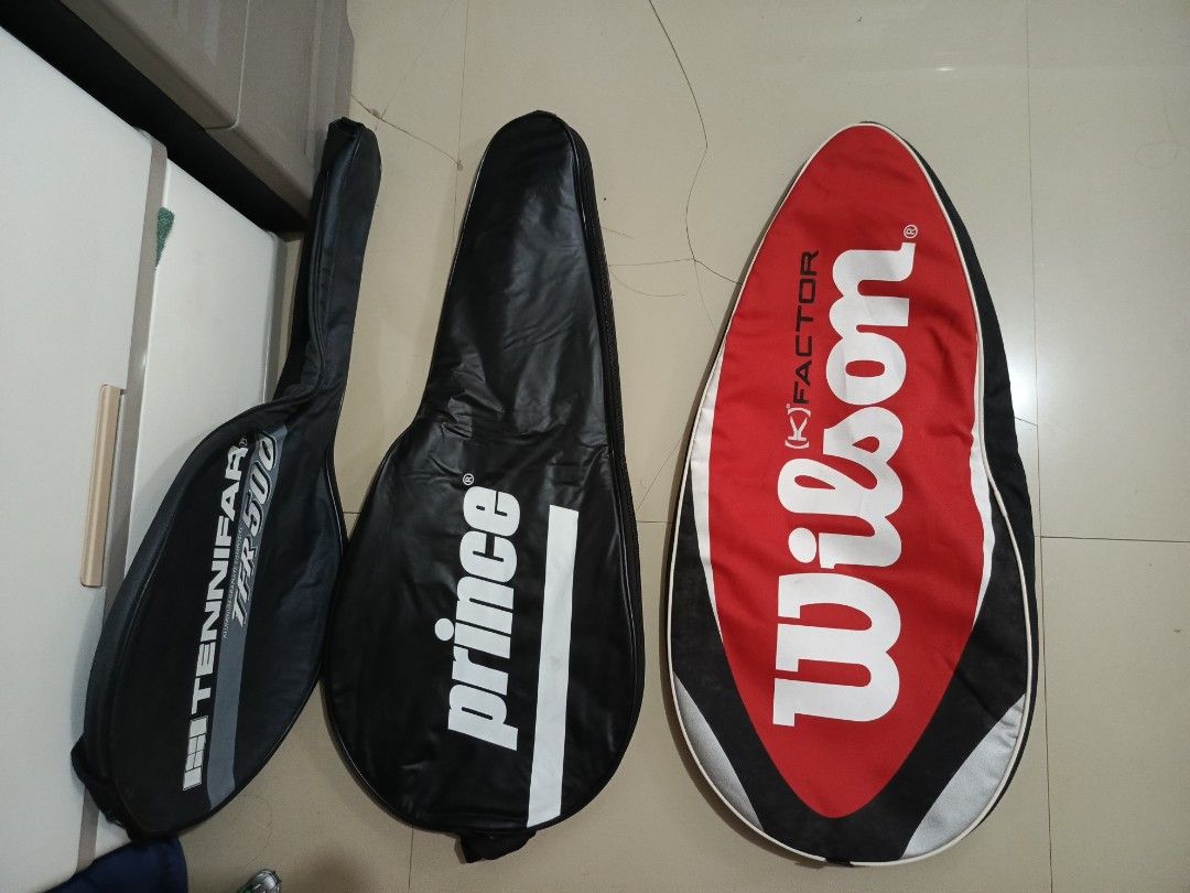 Assorted Tennis Racket Covers Wilson Prince Tennifar (Category: Racket and Ball Sports) located in Irosin. Submitted by whanchore55263 (Listing ID 1467106545, Image 1). Description: Three tennis racket covers up for grabs. Includes a red and black Wilson K Factor cover, a black Prince cover, and a black Tennifar TFR 500 cover with Japana tag inside. Solid zipper closures and soft interior lining on all three to keep rackets protected during trans