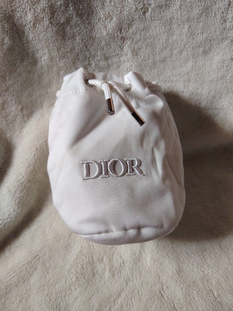 Authentic Dior Beauty White Drawstring Pouch (Category: Purses & Pouches) located in Manila. Submitted by tabuzomaria1422 (Listing ID 1469411200, Image 1). Description: - Brand: Dior Beauty - Color: Classic White - Material: 100% Lyocell body with 100% polyester lining - Features: Embroidered Dior logo on the front and silver-tone hardware on the pull cords - Interior: Includes product code tag (7424243860) and care instructions - Condition: Clea