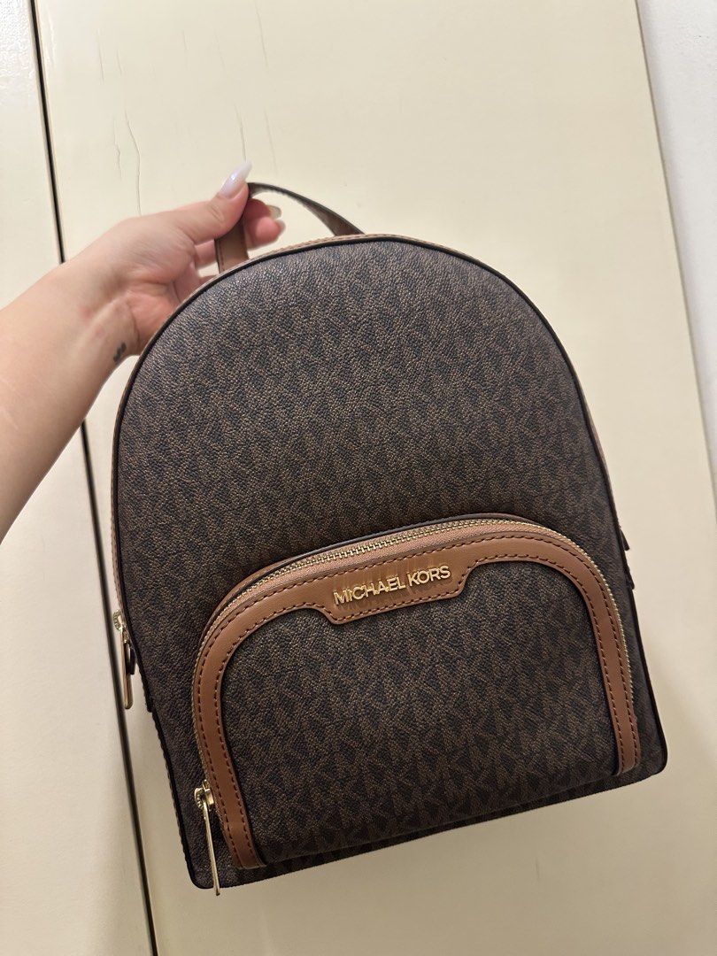 AUTHENTIC Michael Kors Brown Signature Logo Backpack (Category: Backpacks) located in Rizal. Submitted by yagrlkia (Listing ID 1469563795, Image 1). Description: - Brand: Michael Kors - Design: Brown signature print with tan leather trim and gold-tone hardware - Storage: Multiple secure zippered compartments and front pocket with metal logo lettering - Comfort: Convenient top handle and adjustable shoulder straps - Condition: Clean interior and e