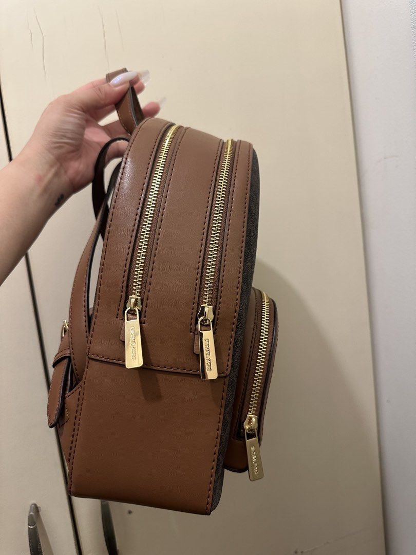AUTHENTIC Michael Kors Brown Signature Logo Backpack (Category: Backpacks) located in Rizal. Submitted by yagrlkia (Listing ID 1469563795, Image 3). Description: - Brand: Michael Kors - Design: Brown signature print with tan leather trim and gold-tone hardware - Storage: Multiple secure zippered compartments and front pocket with metal logo lettering - Comfort: Convenient top handle and adjustable shoulder straps - Condition: Clean interior and e