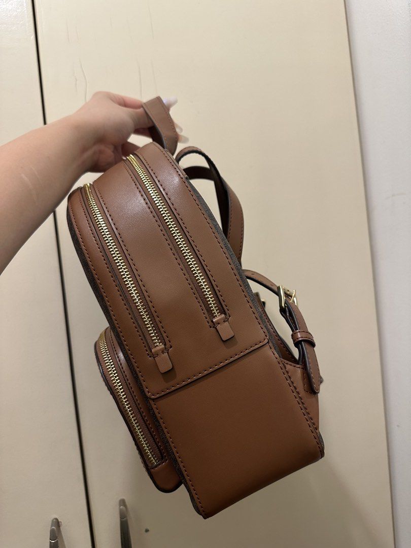 AUTHENTIC Michael Kors Brown Signature Logo Backpack (Category: Backpacks) located in Rizal. Submitted by yagrlkia (Listing ID 1469563795, Image 2). Description: - Brand: Michael Kors - Design: Brown signature print with tan leather trim and gold-tone hardware - Storage: Multiple secure zippered compartments and front pocket with metal logo lettering - Comfort: Convenient top handle and adjustable shoulder straps - Condition: Clean interior and e