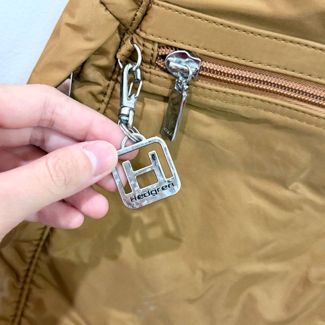 [Authentic] Used Hedgren Brown Nylon Backpack Front Zipper Pocket Keychain Lightweight Bag (Category: Backpacks) located in Quezon City. Submitted by brandedusagoodies (Listing ID 1469552081, Image 3). Description: Used Hedgren backpack in a brown color with a lightweight nylon-style exterior, metallic brand logo, and signature Hedgren keychain charm. It features a front zippered pocket, side pockets, adjustable shoulder straps, and a spacious ma