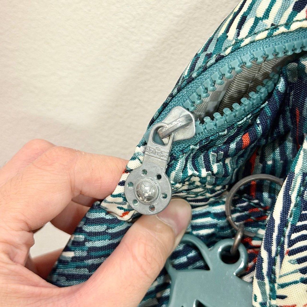 [Authentic] Used Kipling City Pack Teal Blue Abstract Print Nylon Backpack Monkey Charm Lightweight Bag (Category: Backpacks) located in Quezon City. Submitted by brandedusagoodies (Listing ID 1469557020, Image 2). Description: Used Kipling backpack featuring a nylon body with an abstract brushstroke print in teal, navy, cream, and orange. It has a front flap closure, a front zippered pocket with a teal Kipling logo patch, side zippered pockets, 