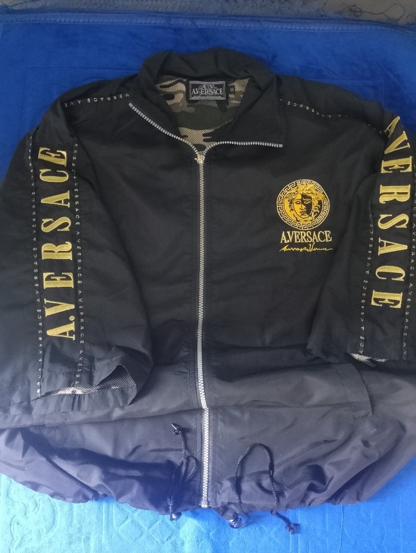 AV By Aversace Diffusion Black Gold Jacket Size M (Category: Coats, Jackets and Outerwear) located in Manila. Submitted by wonderboi80 (Listing ID 1469400021, Image 1). Description: - Brand: AV By Aversace Diffusion - Color: Black with bold gold embroidery on chest, back, and sleeves - Size: Medium (true to size) - Material: 100% nylon outer shell with breathable camo mesh inner lining - Features: Full front zipper, stand-up collar, and adjustabl