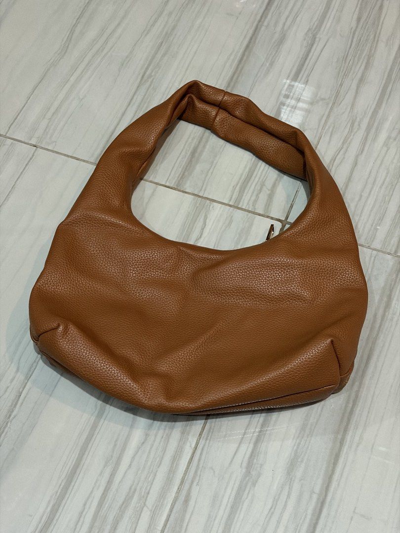 Aztrid Jojo Small Hobo Bag in Tan (Category: Shoulder Bags) located in Morong. Submitted by krmkim (Listing ID 1469451145, Image 2). Description: Bought in July 2024. Old design. No Aztrid logo yet. Lightly used only. RFS: Too small. I had to buy the large one. Dimensions: Width: 11 cm Height: 19 cm Length: 34 cm Material: Pebbled Vegan Leather Details: Color: Tan Type of closure: Single Zip Metal Compartments: One Zippered Pocket Lining: Premium