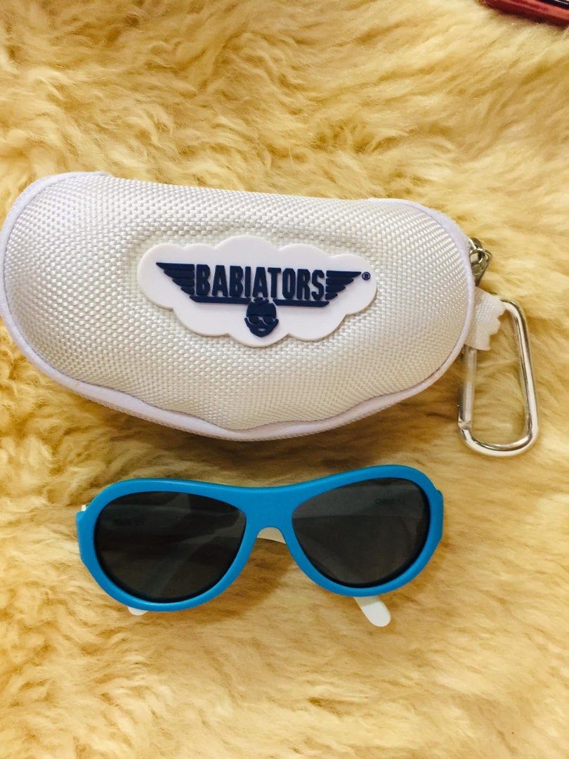 Babiators Kids Sunglasses Ages 3-5 with Case (Category: Babies & Kids Fashion) located in Baguio. Submitted by izza_thrifty (Listing ID 1469567975, Image 1). Description: - Brand: Babiators - Color: Blue and white with fun sneaker pattern on temples - Size: Kids ages 3 to 5 years old - Protection: Dark tinted lenses for reliable sun protection - Inclusion: Matching white hard zipper case with carabiner clip - Ideal for: Outdoor play and sunny day