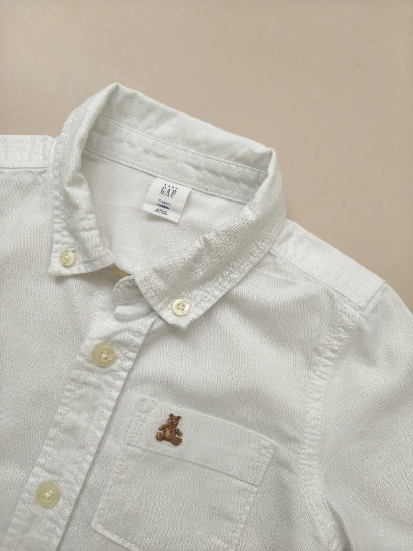 Baby Gap White Short Sleeve Button Down Shirt 3yo (Category: Babies & Kids Fashion) located in Cebu City. Submitted by little_mush.room (Listing ID 1469452223, Image 2). Description: - Brand: Baby Gap - Size: 3 Years (Toddler) - Color: Classic White - Material: Soft Cotton - Details: Short sleeves, button-down front, classic collar, chest pocket with cute embroidered bear, and curved back hem - Condition: Clean and ready to wear.