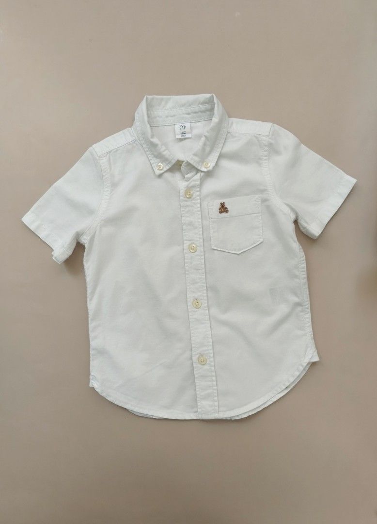 Baby Gap White Short Sleeve Button Down Shirt 3yo (Category: Babies & Kids Fashion) located in Cebu City. Submitted by little_mush.room (Listing ID 1469452223, Image 1). Description: - Brand: Baby Gap - Size: 3 Years (Toddler) - Color: Classic White - Material: Soft Cotton - Details: Short sleeves, button-down front, classic collar, chest pocket with cute embroidered bear, and curved back hem - Condition: Clean and ready to wear.