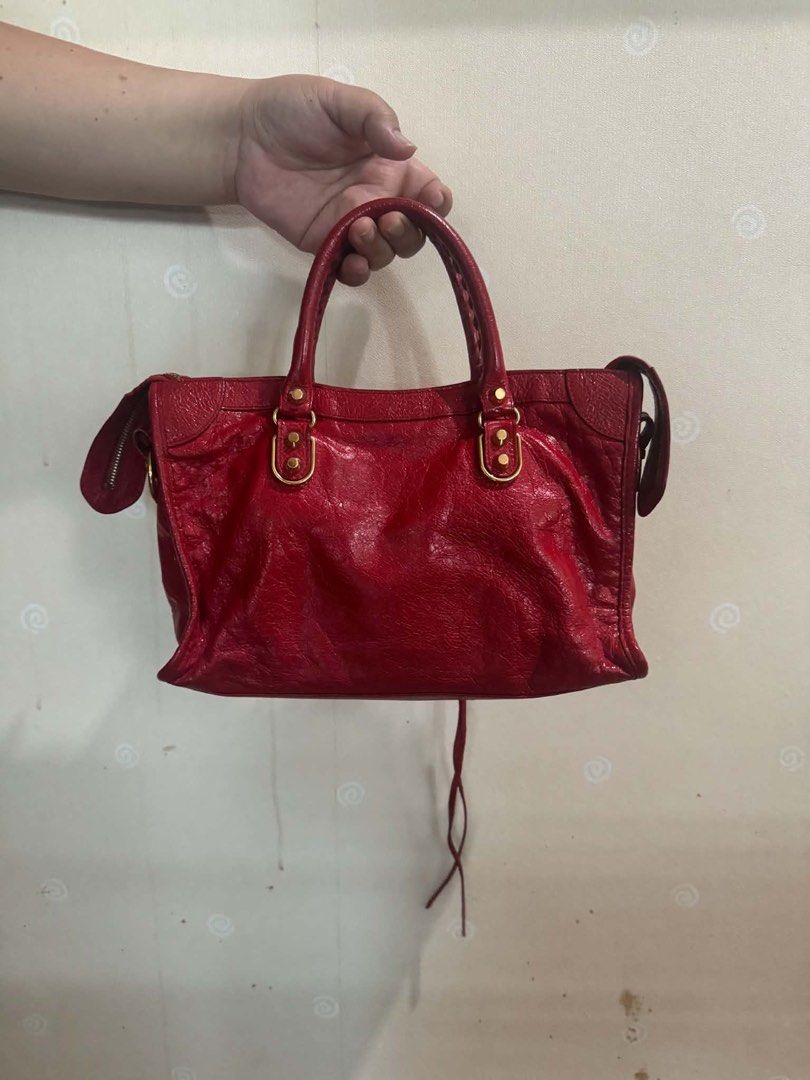 Balenciaga City Bag Red Leather (Category: Luxury Bags & Wallets) located in Balagtas. Submitted by momandkidstuffph (Listing ID 1469410013, Image 2). Description: - Brand: Balenciaga - Color: Bright Red with Gold-tone hardware - Material: Distressed crinkled leather - Features: Front zip pocket, top zip closure, double top handles, and side tassel detail - Condition: Clean interior and corners, well-maintained timeless style.