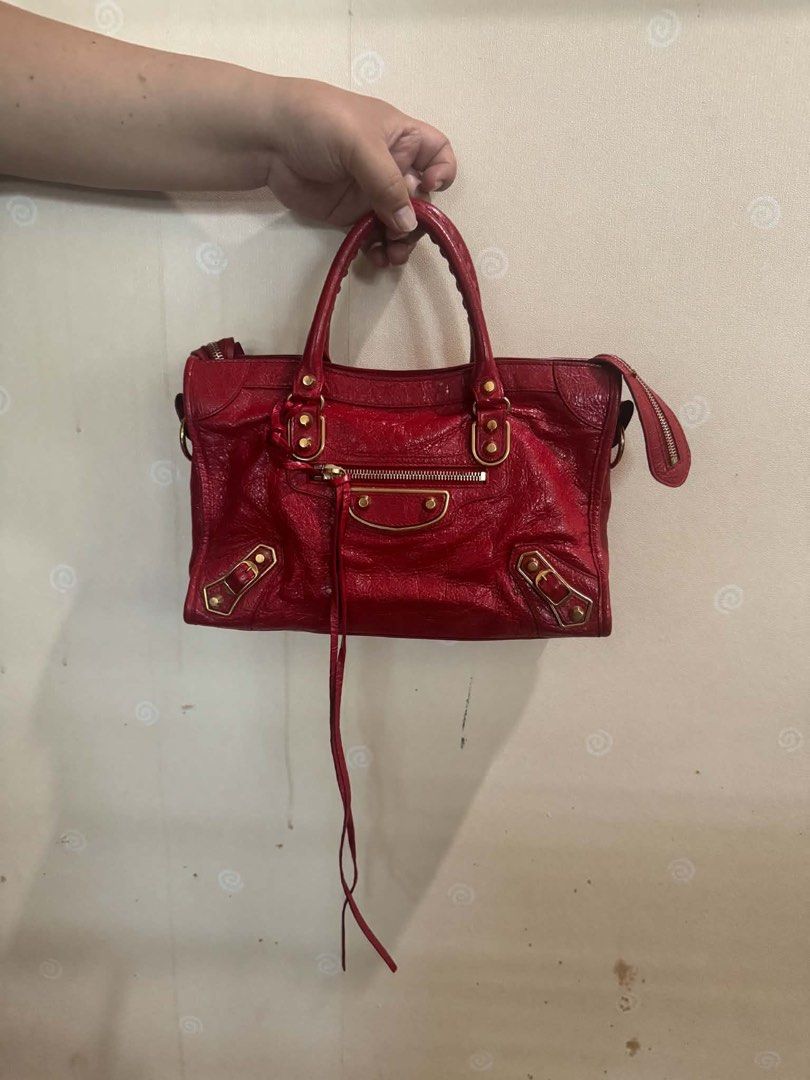 Balenciaga City Bag Red Leather (Category: Luxury Bags & Wallets) located in Balagtas. Submitted by momandkidstuffph (Listing ID 1469410013, Image 1). Description: - Brand: Balenciaga - Color: Bright Red with Gold-tone hardware - Material: Distressed crinkled leather - Features: Front zip pocket, top zip closure, double top handles, and side tassel detail - Condition: Clean interior and corners, well-maintained timeless style.
