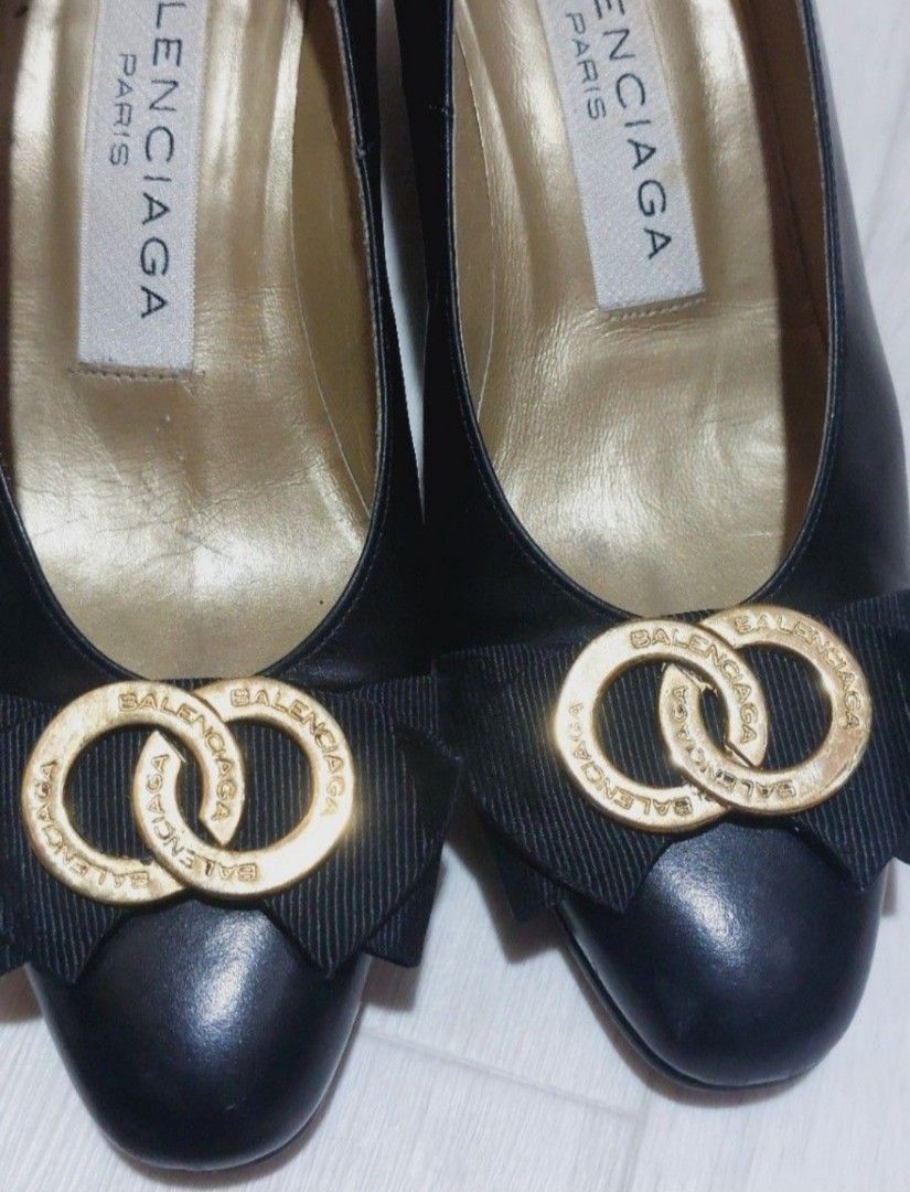 Balenciaga Pump Heels (Category: Sneakers & Footwear) located in Muntinlupa City. Submitted by sakurambo_des (Listing ID 1469418074, Image 2). Description: Balenciaga Paris Pump Heels Size 35 eur / 1 inches tall heels Material: Black leather / patent leather with fabric bow Design: Round or pointed-toe pumps with gold-tone circular buckle and ribbon/bow embellishment..