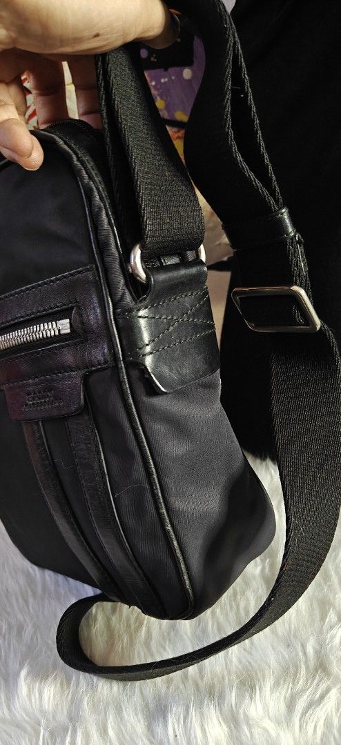 Bally Black Nylon Crossbody Bag (Category: Sling Bags) located in Las Pinas. Submitted by liezel49 (Listing ID 1469424224, Image 2). Description: - Brand: Bally Crossbody Bag - Material: Durable black nylon with sleek leather trim - Storage: Secure zip-top closure plus an extra zipped front pocket - Strap: Comfortable, adjustable wide shoulder strap - Condition: Clean interior with sturdy hardware throughout - Size: Compact design, ideal for dail