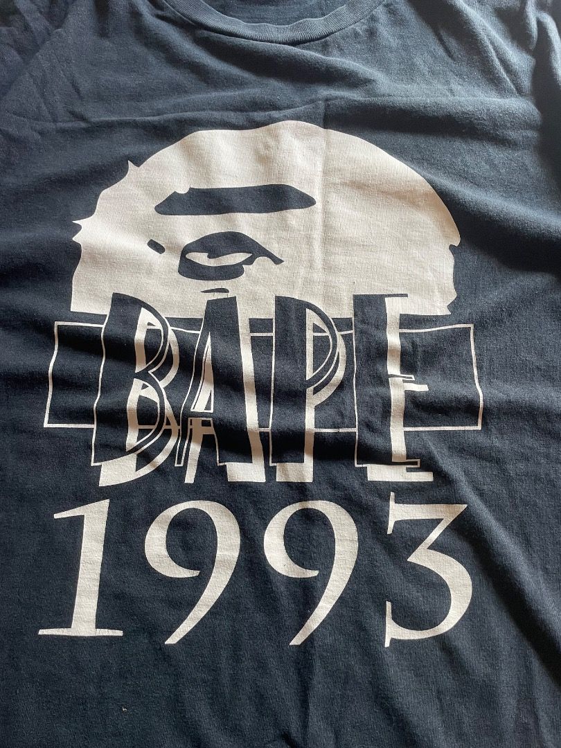BAPE 1993 Graphic T-Shirt (Category: Tshirts & Polo Shirts ) located in Puerto Princesa. Submitted by bestthrift123 (Listing ID 1469433002, Image 2). Description: - Brand: BAPE - Design: Iconic 1993 large front graphic with ape head logo - Details: Signature small embroidered BAPE tag on the sleeve hem - Fit & Fabric: Comfortable relaxed fit made from premium cotton - Style: Casual streetwear essential - Condition: Brand new / Excellent.