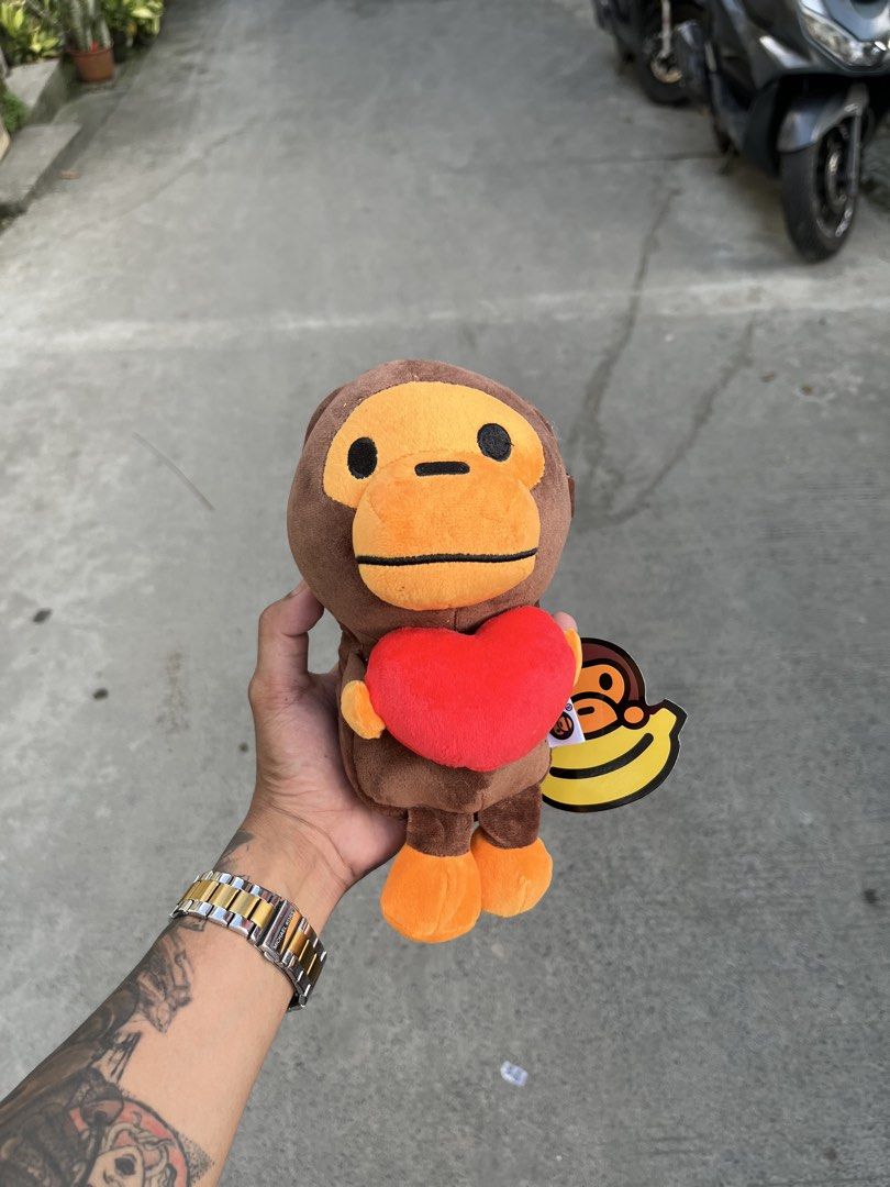 BAPE Baby Milo Plush Toy Collection (Category: Plushies & Soft Toys) located in Manila. Submitted by donthriftph. (Listing ID 1469469024, Image 3). Description: - Set of 4 authentic Baby Milo plush toys - Includes 4 designs: Pink shark hoodie, blue shark hoodie, holding a red heart, and eating a donut - All plushies come with original banana hang tags still attached - Material is ultra-soft, clean, and in pristine condition - Zero stains, flaws, 