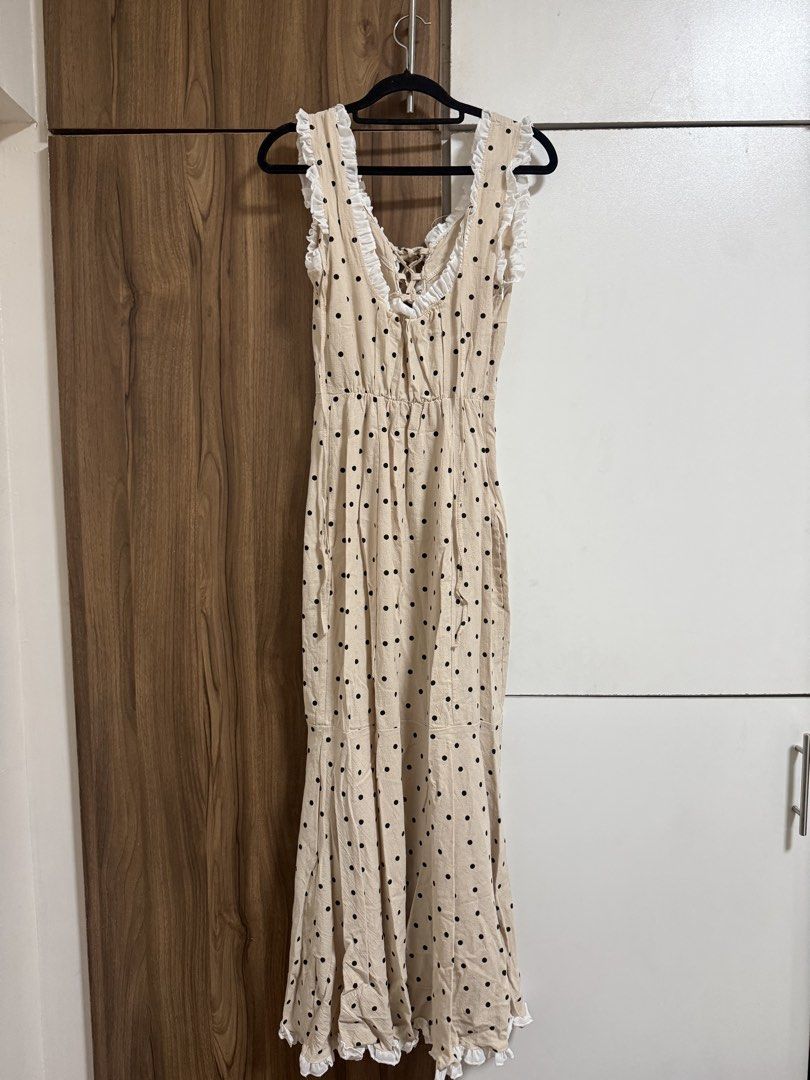 Beige Polka Dot Ruffle Maxi Dress (Category: Dresses) located in Binangonan. Submitted by curatedbyjuys (Listing ID 1469441329, Image 3). Description: - Color/Pattern: Beige with all-over black polka dots - Design details: White ruffled trim on neckline and straps with a front lace-up closure - Fit & Closure: Convenient side zipper closure - Hemline: Long, flared style with a ruffled bottom edge - Condition: Brand new / Excellent quality - Mode o