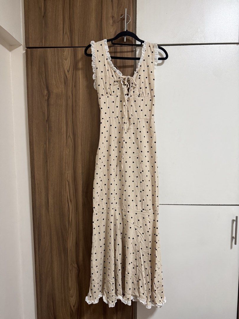 Beige Polka Dot Ruffle Maxi Dress (Category: Dresses) located in Binangonan. Submitted by curatedbyjuys (Listing ID 1469441329, Image 1). Description: - Color/Pattern: Beige with all-over black polka dots - Design details: White ruffled trim on neckline and straps with a front lace-up closure - Fit & Closure: Convenient side zipper closure - Hemline: Long, flared style with a ruffled bottom edge - Condition: Brand new / Excellent quality - Mode o