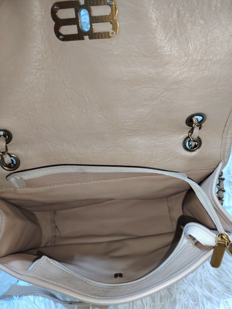 Beige shoulder bag with chain strap and gold BB clasp (Category: Cross-body Bags) located in Quezon City. Submitted by zhelcloset01 (Listing ID 1469505708, Image 3). Description: - Style: Beige leather-look shoulder bag - Closure: Flap top with gold-tone double B metal clasp - Strap: Intertwined chain and leather in matching beige - Interior: Fabric-lined with a zippered pocket divider - Exterior: Back slip pocket for quick access - Details: Soft