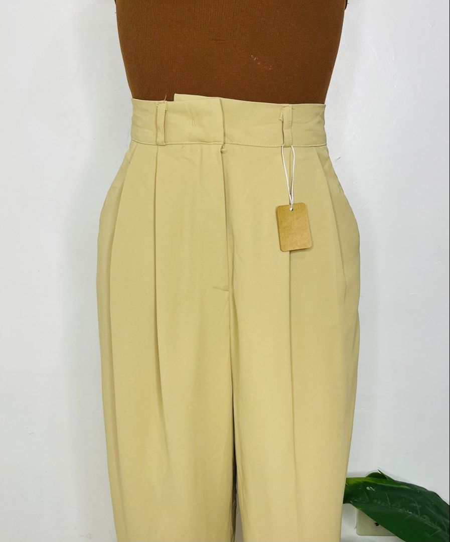 Beige Trousers Pants | Size 24-25 (Category: Trousers) located in Manila. Submitted by bengirlclothing (Listing ID 1469485870, Image 3). Description: - Color: Classic Beige - Fit: High-waist with straight leg - Details: Front pleats, belt loops, and two back pockets with welt detailing - Condition: Brand new with tag attached - Style: Clean, structured, and versatile for work or casual wear.