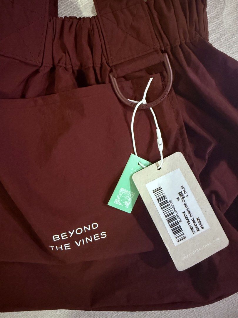 Beyond The Vines Dumpling Bag Maroon XS (Category: Cross-body Bags) located in Bacolod City. Submitted by dwitanic (Listing ID 1469428978, Image 2). Description: - Brand: Beyond The Vines - Item: Seasonal Dumpling Bag - Color: Maroon - Size: XS - Condition: Brand new with original tags - Material: Lightweight nylon - Features: Front pocket with white logo lettering, top handles, and an adjustable crossbody strap - Functionality: Practical everyda