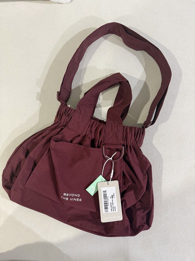 Beyond The Vines Dumpling Bag Maroon XS (Category: Cross-body Bags) located in Bacolod City. Submitted by dwitanic (Listing ID 1469428978, Image 1). Description: - Brand: Beyond The Vines - Item: Seasonal Dumpling Bag - Color: Maroon - Size: XS - Condition: Brand new with original tags - Material: Lightweight nylon - Features: Front pocket with white logo lettering, top handles, and an adjustable crossbody strap - Functionality: Practical everyda