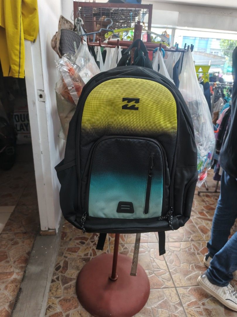 Billabong Black Yellow Teal Gradient Backpack (Category: Backpacks) located in Bayombong. Submitted by onlygoodfinds. (Listing ID 1469409616, Image 1). Description: - Brand: Billabong - Colorway: Black, yellow, and teal gradient - Comfort: Mesh back padding and adjustable shoulder straps with branded tag - Storage: Spacious main compartment for books/gear plus front zipped compartment with branded patch and pulls - Condition: Durable fabric that 
