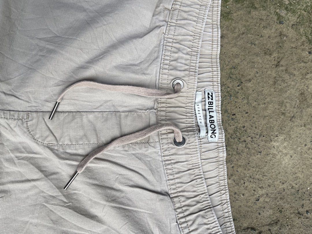 Billabong Stretch Drawstring Casual Shorts Beige (Category: Shorts) located in Manila. Submitted by thrifttika (Listing ID 1469446655, Image 2). Description: - Brand: Billabong - Color: Beige - Material: Comfortable stretch fabric - Waistband: Elastic with drawstring closure & inside branding tag - Hardware: Metal eyelets and aglets - Pockets: Dual side pockets and back welt pockets - Details: Black Billabong woven logo patch near the hem - Fit: 