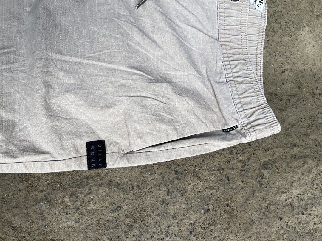 Billabong Stretch Drawstring Casual Shorts Beige (Category: Shorts) located in Manila. Submitted by thrifttika (Listing ID 1469446655, Image 3). Description: - Brand: Billabong - Color: Beige - Material: Comfortable stretch fabric - Waistband: Elastic with drawstring closure & inside branding tag - Hardware: Metal eyelets and aglets - Pockets: Dual side pockets and back welt pockets - Details: Black Billabong woven logo patch near the hem - Fit: 
