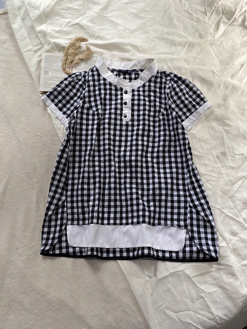 Black and white gingham short sleeve button blouse Large 40 (Category: Blouses) located in Poro. Submitted by joyceyuu (Listing ID 1469405957, Image 1). Description: - Style: Casual black and white checkered blouse - Features: Short sleeves, button-up front, and crisp white collar - Details: White contrast fabric on the bottom hem and sleeve cuffs - Versatility: Easy to style with your favorite jeans or skirts - Condition: Brand new / Excellent q