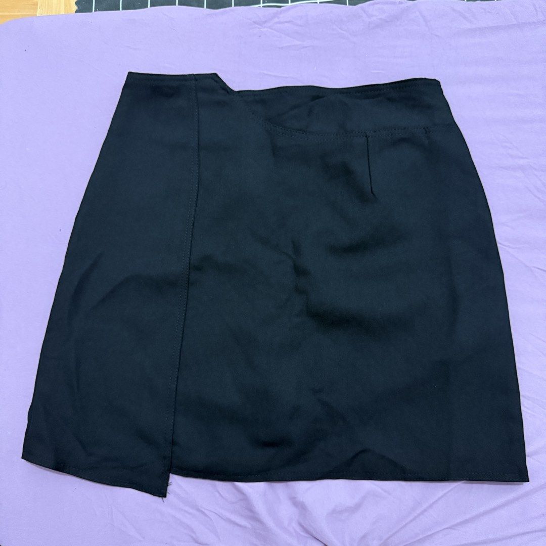 Black Asymmetric Hem Mini Skirt (Category: Skirts) located in Legazpi City. Submitted by maerixx (Listing ID 1469508404, Image 1). Description: Size 26 - Color: Black - Style: Mini skirt with asymmetrical wrapped front - Closure: Concealed back zip - Fit: Sits around mid-thigh, smooth fabric with minimal stretch - Condition: Excellent, no stains or loose threads - Pairing: Easy to match with crop tops and basic tees.