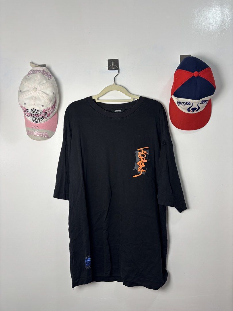 Black Graphic Oversized T-Shirt Orange Print (Category: Tshirts & Polo Shirts ) located in Calbayog City. Submitted by zaxcheus_castillo1708 (Listing ID 1469523625, Image 1). Description: - Color: Black - Fit: Oversized with relaxed drop shoulders - Design: Orange graphic text on front chest; large collage graphic with orange graffiti lettering on the back - Details: Round neckline and small woven label tag near the bottom right hem - Style: Stre