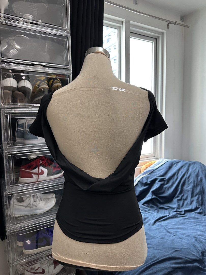 Black open back short sleeve top (Category: Blouses) located in Quezon City. Submitted by valeriorac74670 (Listing ID 1469454907, Image 2). Description: - Color: Classic Black - Fit: Form-fitting, cropped length - Neckline: Scoop front - Back Design: Deep low-cut open back with a stylish draped twist detail - Fabric: Soft, highly comfortable stretch material - Styling: Perfect to pair with high-waisted jeans, shorts, or skirts - Condition: Clean 