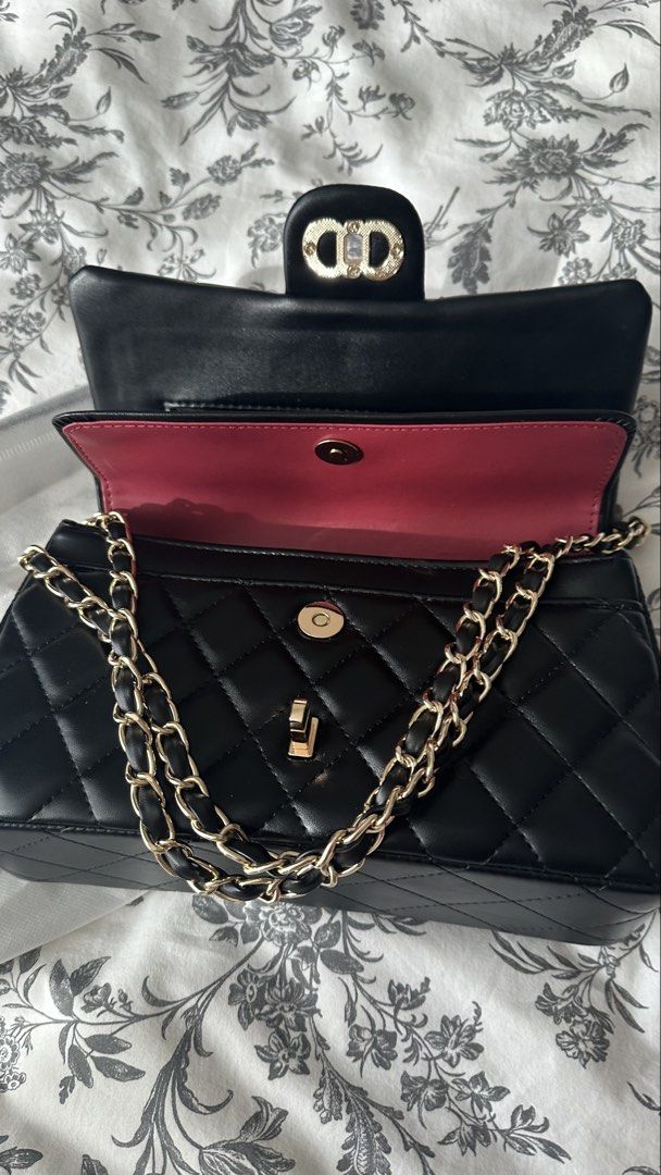 Black Quilted Handbag with Chain Strap (Category: Shoulder Bags) located in Quezon City. Submitted by mommyjoanne24 (Listing ID 1469396344, Image 2). Description: - Color: Classic black with striking bright pink inner lining - Design: quilted pattern - Strap: gold-tone chain interwoven with black material (can be worn shoulder or cross body) - Closure: Secure magnetic snap button under the flap - Condition: New - Inclusions: Comes with dust bag.