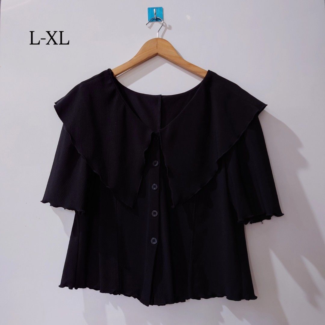 Black ribbed button-up blouse with large collar size L-XL (Category: Blouses) located in Diffun. Submitted by declutteredbyJill (Listing ID 1469570064, Image 1). Description: - Color: Black - Size: L-XL - Material: Textured fabric, slightly stretchy - Design: Wide collar, short sleeves, and 5 front buttons - Details: Lettuce hem finish on cuffs and bottom edge - Styling: Great to pair with skirts or high-waisted pants.