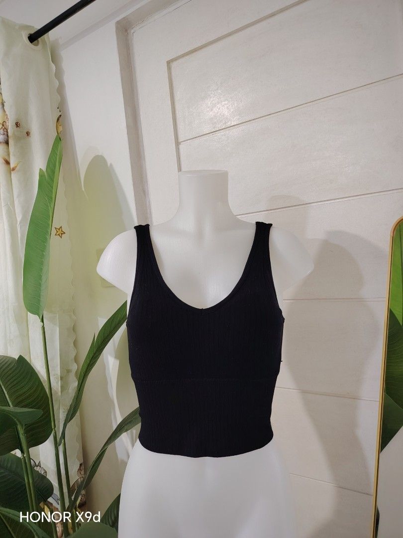 Black Ribbed Crop Top With Built-In Padding (Category: Sleeveless) located in Mabalacat. Submitted by Jackikay.PreLoved (Listing ID 1469511757, Image 2). Description: - Color: Black - Style: Ribbed crop top with deep V-neck - Straps: Thick front straps and trendy double thin back straps - Comfort: Built-in bra padding included (no need for innerwear) - Fit: Stretchy knit material that hugs the body closely.