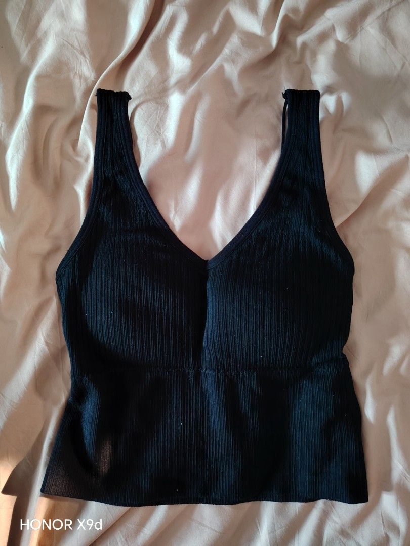 Black Ribbed Crop Top With Built-In Padding (Category: Sleeveless) located in Mabalacat. Submitted by Jackikay.PreLoved (Listing ID 1469511757, Image 1). Description: - Color: Black - Style: Ribbed crop top with deep V-neck - Straps: Thick front straps and trendy double thin back straps - Comfort: Built-in bra padding included (no need for innerwear) - Fit: Stretchy knit material that hugs the body closely.
