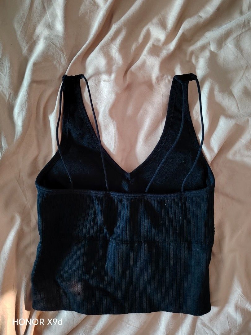 Black Ribbed Crop Top With Built-In Padding (Category: Sleeveless) located in Mabalacat. Submitted by Jackikay.PreLoved (Listing ID 1469511757, Image 3). Description: - Color: Black - Style: Ribbed crop top with deep V-neck - Straps: Thick front straps and trendy double thin back straps - Comfort: Built-in bra padding included (no need for innerwear) - Fit: Stretchy knit material that hugs the body closely.