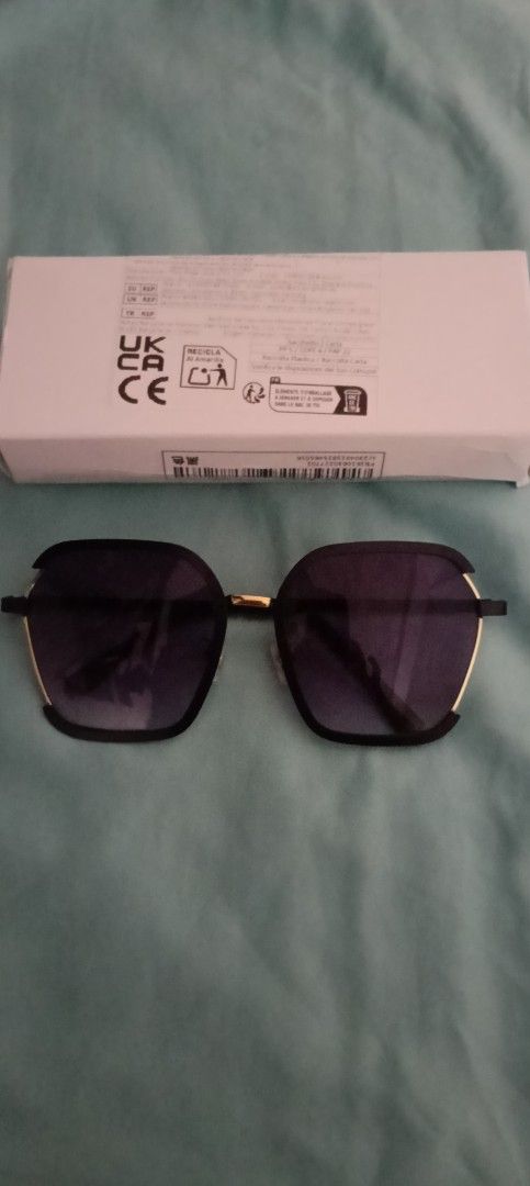 Black Square Sunglasses with Gradient Lenses and Box (Category: Sunglasses & Eyewear) located in Taguig. Submitted by trade_fairly (Listing ID 1469422524, Image 2). Description: - Style: Black square sunglasses with slim metal arms - Lenses: Trendy gradient lenses for everyday wear - Details: Elegant gold accent piece on the bridge - Condition/Inclusions: Brand new feel, includes original white packaging box with barcode and regulatory markings -