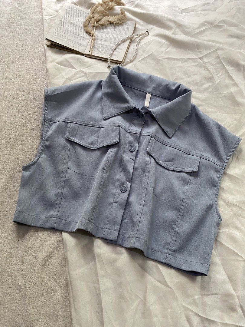 Blue Sleeveless Button-Up Crop Top with Pockets Large 41 (Category: Sleeveless) located in Poro. Submitted by joyceyuu (Listing ID 1469405667, Image 2). Description: - Style: Casual streetwear sleeveless crop top - Color: Light blue - Design: Classic collar, front button closure, and back yoke detail - Pockets: Two functional chest flap pockets - Quality: Structured fit with clean stitching all around - Styling: Pairs effortlessly with high-waist