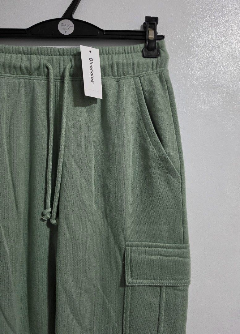 Bluenotes Green Cargo Sweatpants Size XS (Category: Jeans) located in Paranaque City. Submitted by franinnashop (Listing ID 1469459950, Image 2). Description: Declutter - Brand: Bluenotes - Color: Sage Green - Condition: Brand new with original store tag attached - Size: XS (Tag) - Waist: 26 to 30 inches (Elastic with drawstring) - Length: 39 inches - Inseam: 27 inches - Features: Side pockets, utility cargo pockets on both legs, and cuffed ankle
