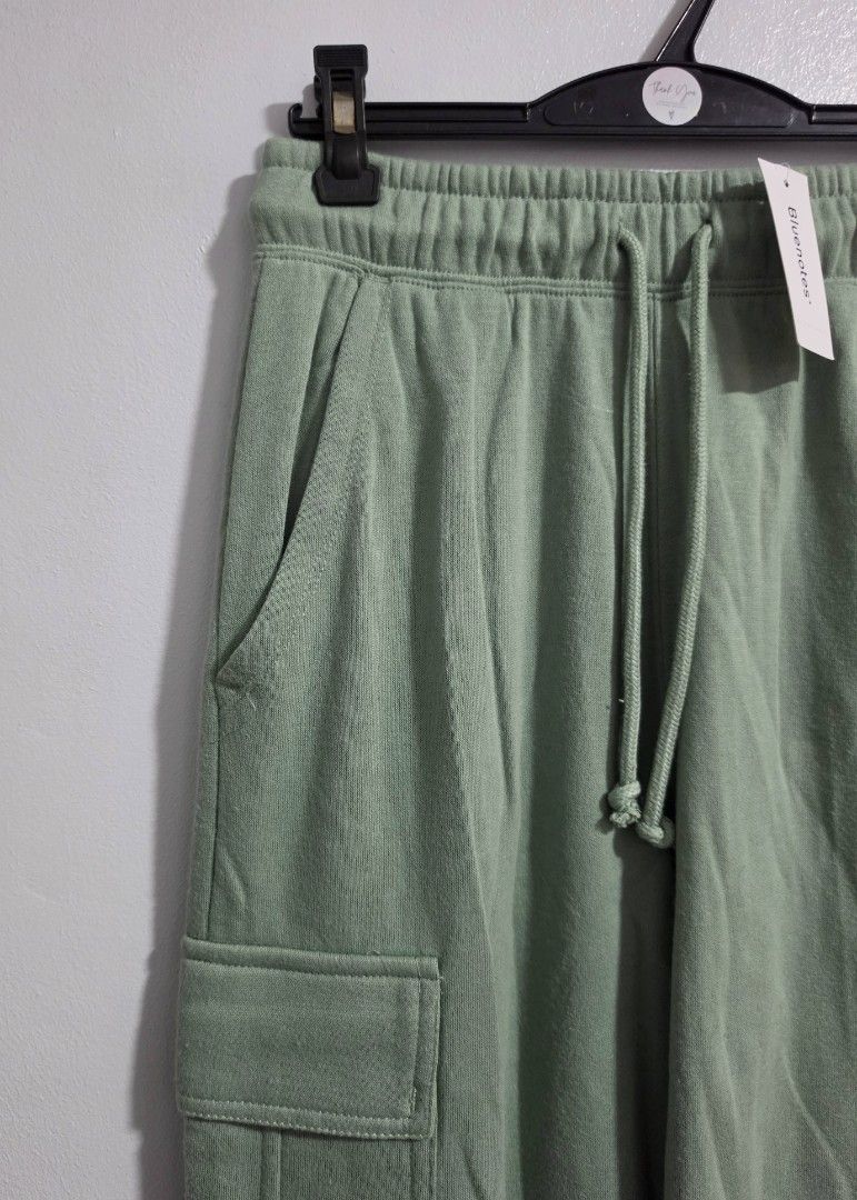 Bluenotes Green Cargo Sweatpants Size XS (Category: Jeans) located in Paranaque City. Submitted by franinnashop (Listing ID 1469459950, Image 3). Description: Declutter - Brand: Bluenotes - Color: Sage Green - Condition: Brand new with original store tag attached - Size: XS (Tag) - Waist: 26 to 30 inches (Elastic with drawstring) - Length: 39 inches - Inseam: 27 inches - Features: Side pockets, utility cargo pockets on both legs, and cuffed ankle