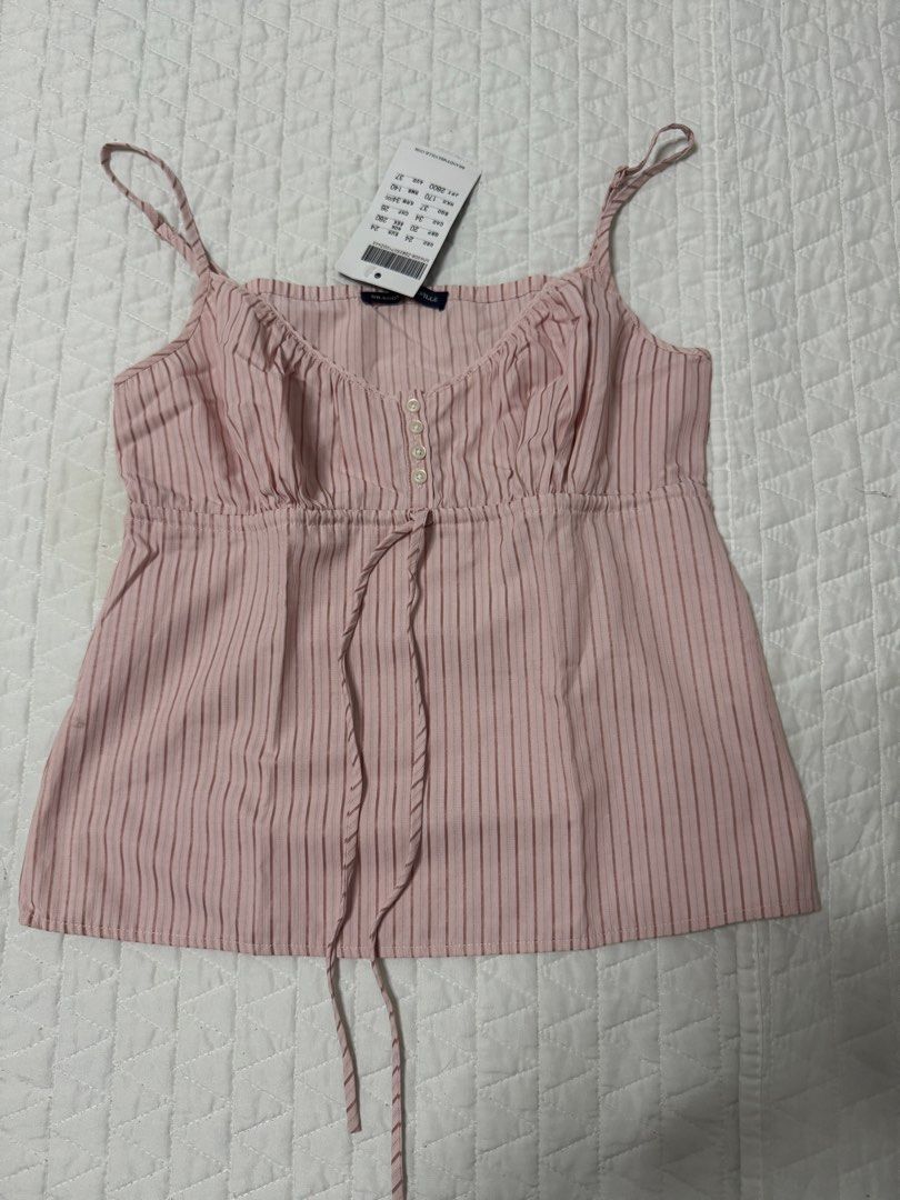 Brandy Melville pink striped cami top with drawstring (Category: Sleeveless) located in Manila. Submitted by mattigarciaa (Listing ID 1469519055, Image 1). Description: - Brand: Brandy Melville - Condition: Brand new with tags (BNWT) - Color: Pink and white striped - Features: Thin adjustable straps, ruched bust, decorative front buttons, drawstring waist tie - Fabric: Lightweight and breathable for warm weather.