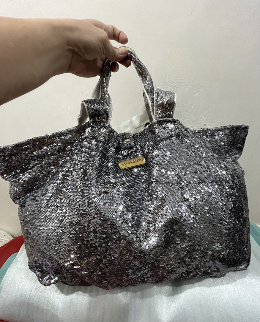 brasi & brasi Silver Sequin Tote Bag (Category: Tote Bags) located in Talisay. Submitted by cherylu (Listing ID 1469570294, Image 2). Description: - Brand: Brasi & Brasi - Material: Fully covered in silver sequins with gold-tone brand plaque - Interior: Dark brown fabric lining with an internal zip pocket - Straps: Dual top handles for easy carrying - Usage: Spacious and stylish, ideal for daily use or casual events.