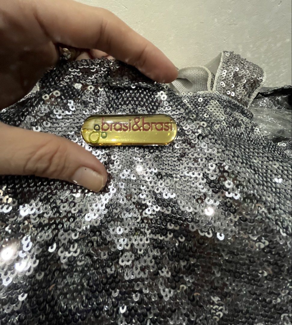 brasi & brasi Silver Sequin Tote Bag (Category: Tote Bags) located in Talisay. Submitted by cherylu (Listing ID 1469570294, Image 3). Description: - Brand: Brasi & Brasi - Material: Fully covered in silver sequins with gold-tone brand plaque - Interior: Dark brown fabric lining with an internal zip pocket - Straps: Dual top handles for easy carrying - Usage: Spacious and stylish, ideal for daily use or casual events.
